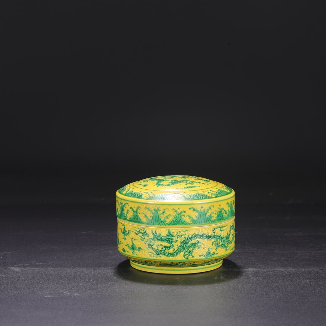 A Ming Dynasty Chenghua period (1460s) yellow-ground green-enamel carved sea and cloud dragon: 10 cm high and 12.5 cm in diameter.