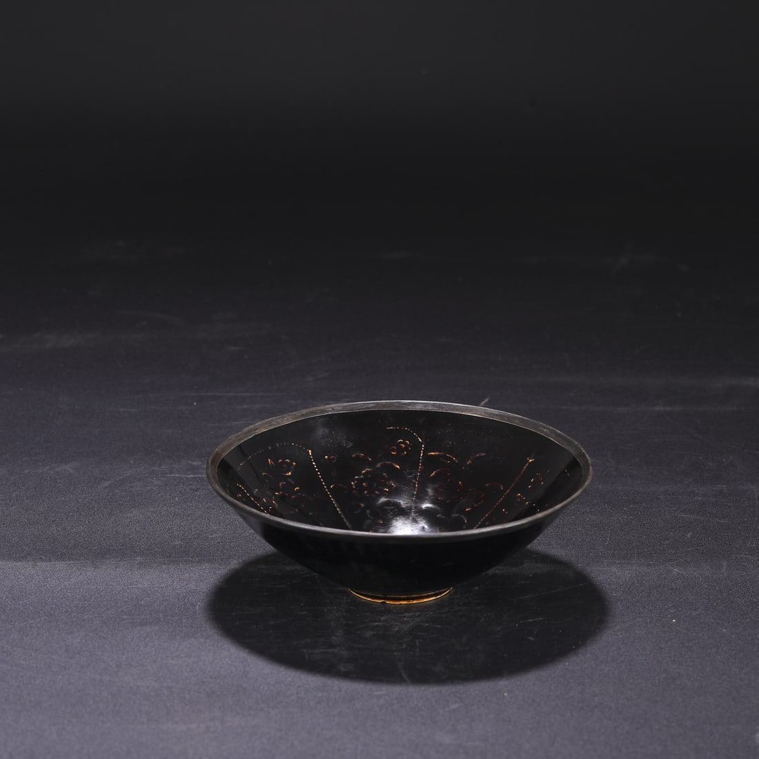 A Northern Song Dynasty Ding ware black-glazed bowl with impressed design and silver rim, formerly: Dimensions: Height 5 cm, Mouth Diameter 14.5 cm.