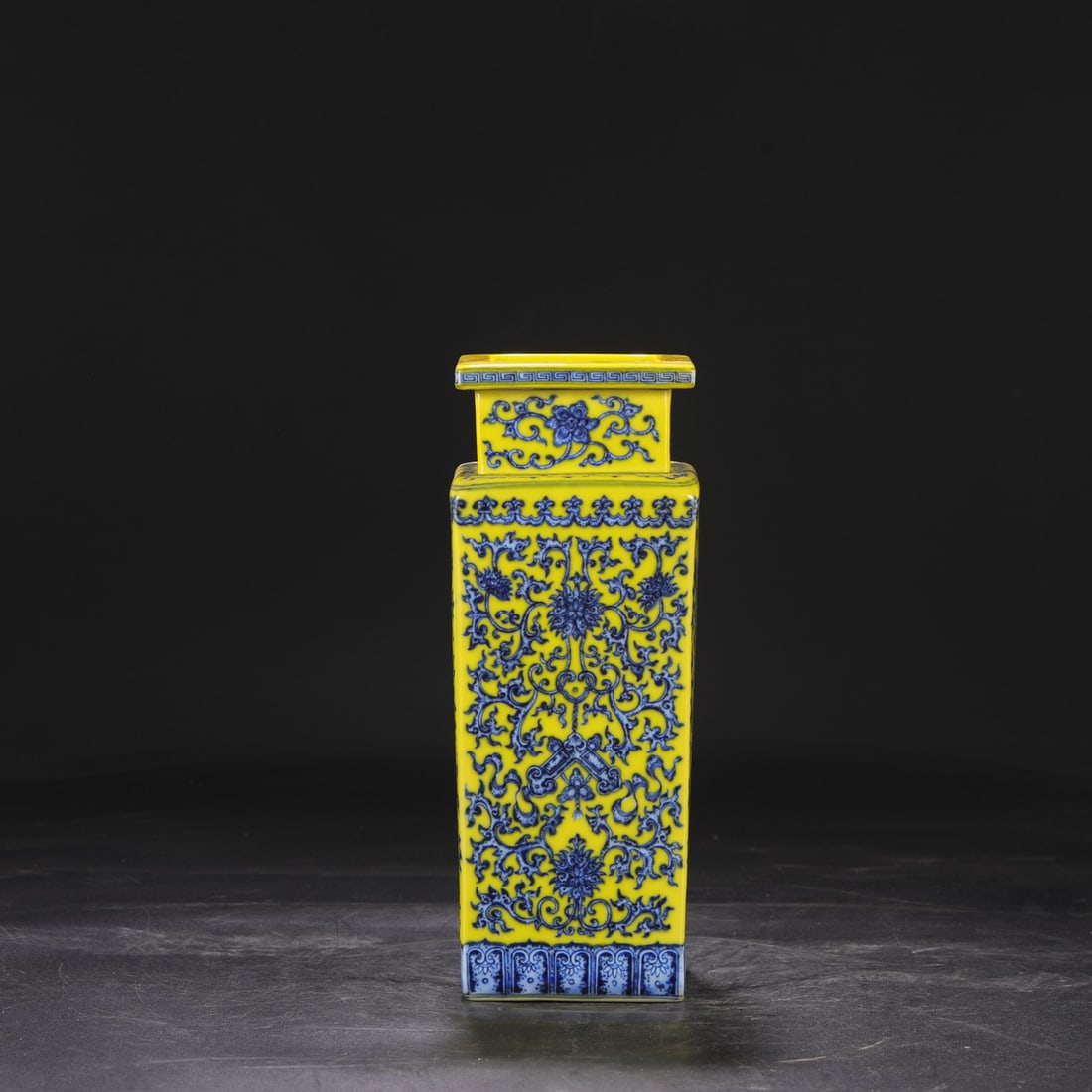 A large square vase with a yellow ground and blue and white lotus scroll design, formerly from the: Dimensions: Height 28.5 cm, Mouth diameter 10.5 cm, Diameter 11 cm.