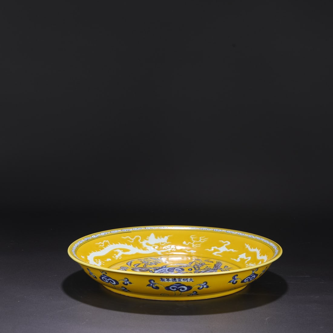 A large Ming dynasty Xuande period yellow-ground blue-and-white porcelain plate with parrot and (1 of 8)