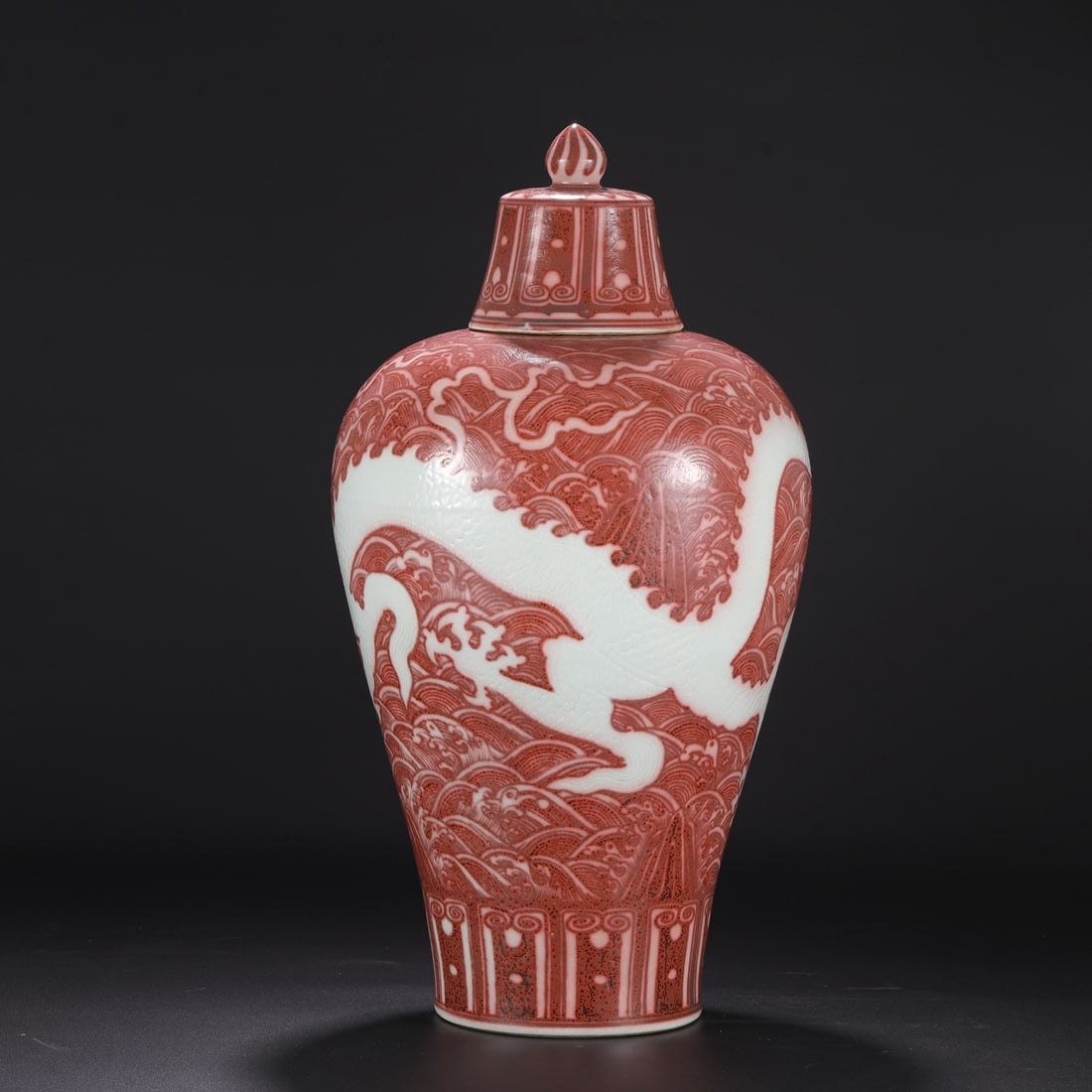 A large Ming Dynasty Hongwu period underglaze red vase with carved sea dragon design and lid, (1 of 8)