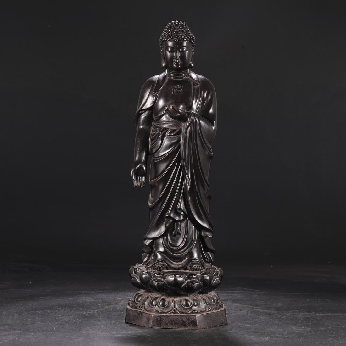 A Qing Dynasty (Qianlong period) standing Buddha statue carved from rosewood on a lotus petal base. (1 of 8)