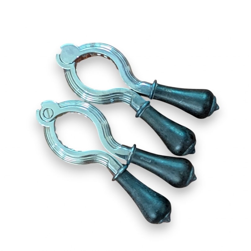 Pair of silver-plated metal cork clips by CHRITOFLE: Pair of silver-plated metal champagne cork clips by CHRITOFLEOrigin: FrancePeriod: 20th centuryMaterials: Silver-plated metalDimensions: Ht 12 x 5.5 x 2 cm