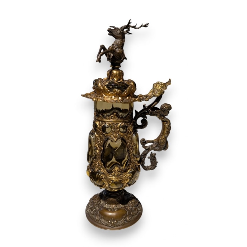 German 19th century Blown glass and gilded bronze mug: A Renaissance-style blown glass and gilt bronze tankard, the lid adorned with a rearing stag, the handle in the form of a winged faun, above a molded circular base with lion masks and cartouches.Origi
