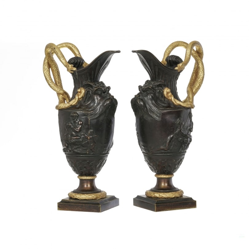 Antique Rare French Pair of ewers after Clodion (1738-1814): Pair of ewers after Clodion (1738-1814) in patinated and gilt bronze, decorated with a mascaron, with serpent handlesOrigin: FrancePeriod: 20th centuryMaterials: BronzeDimensions: Ht 49 x 30 x 18 cm