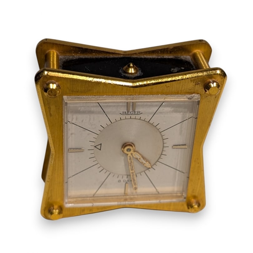 JAEGER Travel Alarm Clock: JAEGER travel alarm clock in gold-plated brass and black enamel. 8-day walking timeOrigin: SwitzerlandPeriod: 20th centuryMaterials: BrassDimensions: Ht 6 x 6 x 3 cm