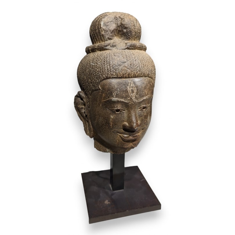 Asian 19th century Head of Shiva carved in stone: Head of Shiva with braided hair held in a domed jatamukuta bun, resting on a metal baseOrigin: AsianPeriod: 19th centuryMaterials: StoneDimensions: Ht 35 x 14 x 14 cm
