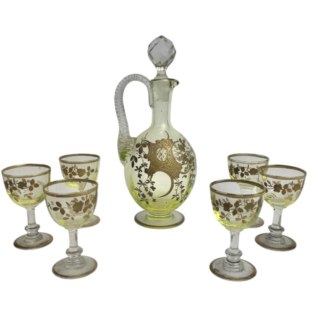 19th century Baccarat - Uranium crystal liqueur service with rocaille and rose decoration: A rare Baccarat liqueur service comprising one decanter and six uranium glass glasses. The decanter, decorated with leaf motifs, rocaille roses, and delicate interlacing lines highlighted in fine gold