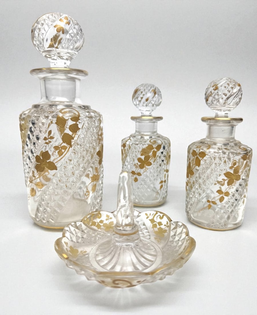 Baccarat "Serpentine" series bathroom set: Baccarat crystal toilet set, Serpentine pattern, decorated with golden flowers, consisting of a 20cm high perfume bottle, two 14cm high perfume bottles and a 7x10cm ring holder.