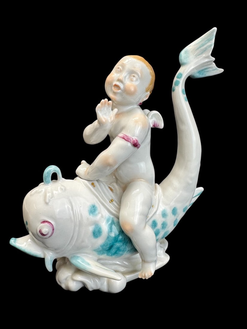 Volkstedt - Porcelain figure of Eros on a dolphin I: A Volkstedt porcelain figurine depicting Eros on a dolphin. This model was created by Emil Paul Börner, one of the most versatile and prolific artists at the Meissen porcelain factory in the 1920s, w
