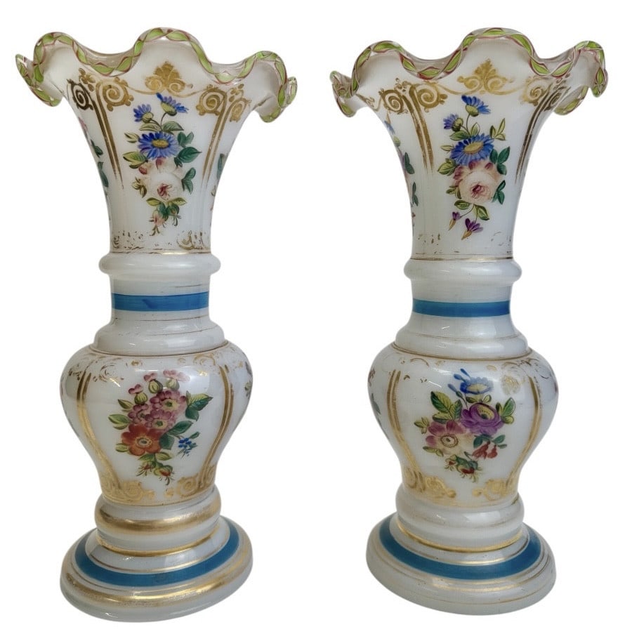 19th century Baccarat - Pair of opaline vases: A pair of baluster vases in white opaline crystal, decorated with polychrome flowers and bouquets, blue and gilt trim, with an undulating rim adorned with a twisted, filigree crystal band in green and
