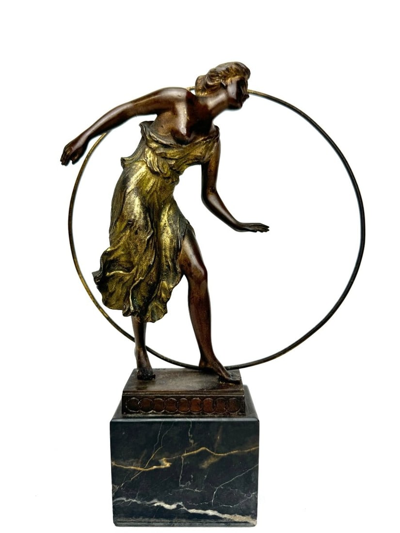 Georges Morin Bronze Figure of a Woman with a Hoop: Bronze figure with brown and gold patina of a graceful woman dancing with a hoop in a long flowing dress, on a flat rectangular base with geometric decoration on a high black marble plinth, circa 1910