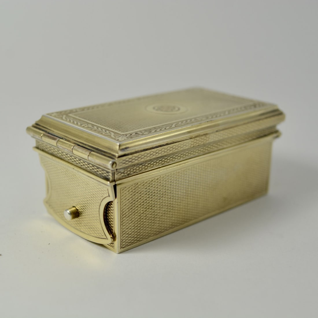 Gilt silver inkwell, France circa 1900, by goldsmith Gustave Keller: A rectangular travel inkwell with a flat base. Made of guilloché and gilt silver, with a hinged lid and locking mechanism. The decoration is trompe-l'œil, with strong rims and fillets; the lid is ad
