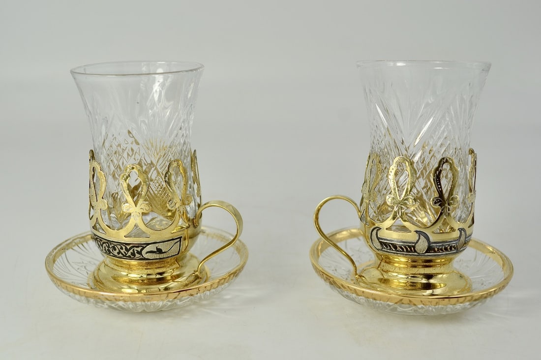 Soviet Russia, pair of crystal and silver-gilt glasses.: Russia, Soviet period, circa 1970.A pair of cut crystal cups in a cone shape, accompanied by their gilt and nielloed silver cup holders, resting on pedestals. The mounts are decorated with an openwork