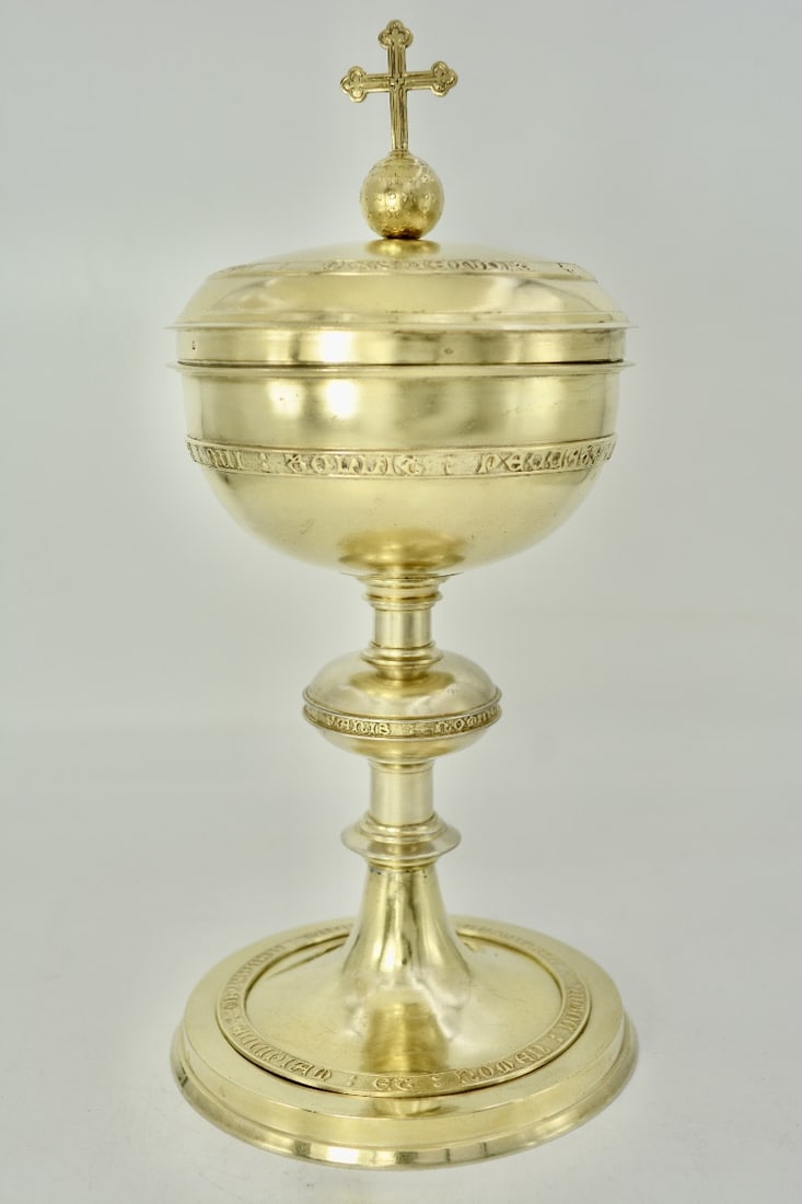 Large ciborium, gilt silver, France, 19th century, by Paul Brunet: A large gilt silver ciborium resting on a circular foot with an overhanging rim. The base bears a Latin inscription in relief, arranged in a circle, and is screwed onto the flat surface. The tapered s