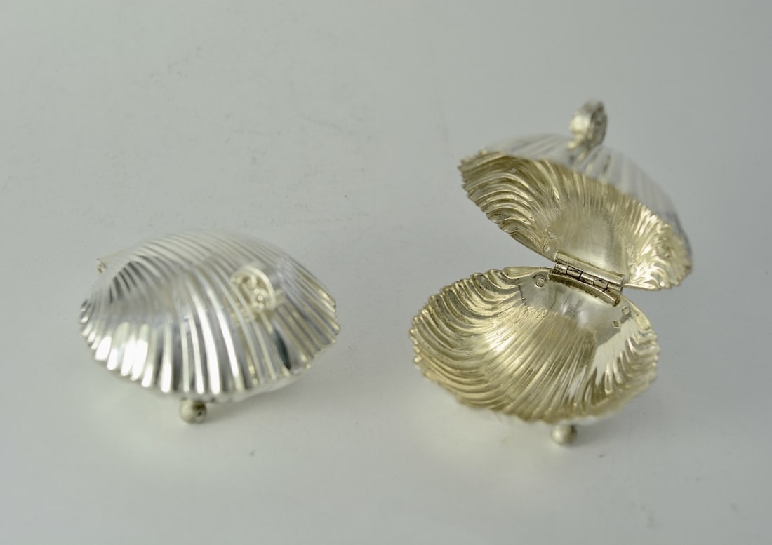 Pair of Caviar Display Stands, Silver, France, Circa 1900: A pair of individual caviar serving dishes in cast and chased silver, each in the form of a shell resting on three bubble-shaped feet. The hinged lid features a scroll handle adorned with a rosette.Fr