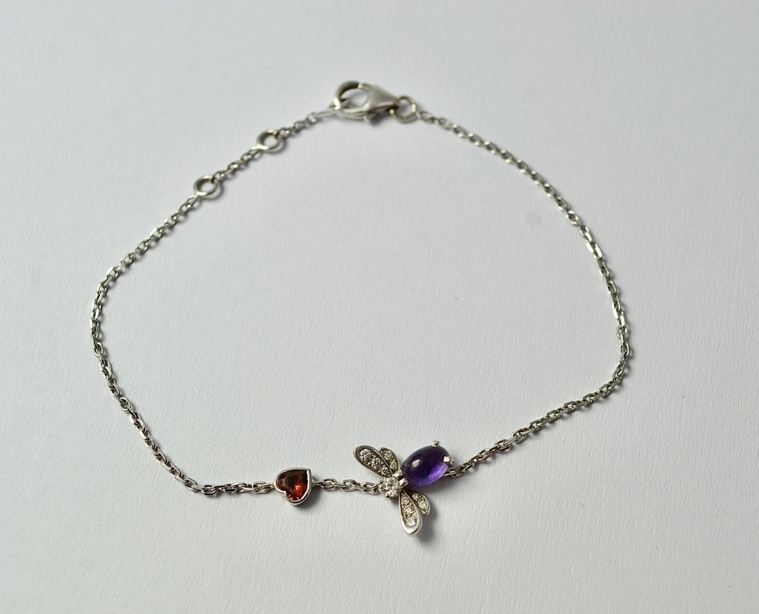 Chaumet Paris. "Catch Me If You Love Me" Bracelet, 18k Gold: Chaumet, "Catch Me If You Love Me" bracelet in 18k white gold, featuring a bee motif adorned with a cabochon amethyst, a heart-shaped tourmaline, and small pavé-set diamonds. Spring ring clasp.Signed