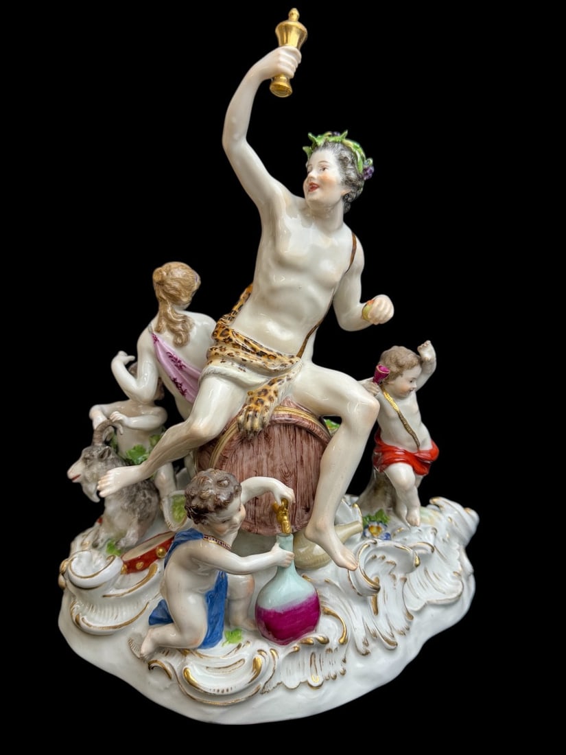 Meissen - Porcelain group - Bacchus on a barrel.: Meissen porcelain group with four figures: Bacchus seated on a barrel, raising a wine cup; a woman seated behind the barrel with a basket of fruit; a child seated in front of the barrel filling a bott