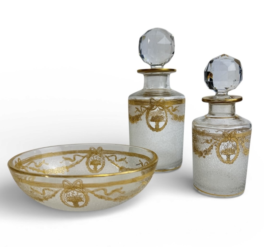 Saint Louis - Empire period crystal toilet set: A Saint Louis crystal toiletry set, comprising a 16x6.5cm perfume bottle, a 12x4.8cm perfume bottle, and an oval dish measuring 4x12x9cm. Decorated with delicate garlands of gilded flowers and a centr