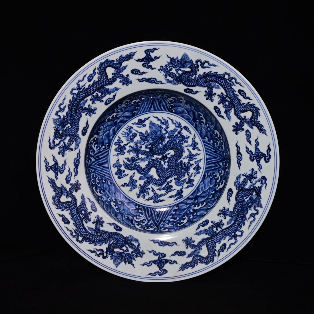A blue-and-white porcelain dish with a five-dragon design: A blue-and-white porcelain dish with a five-dragon design, made during the Xuande period of the Ming Dynasty, measuring 10.3 x 47.8 cm in height.
