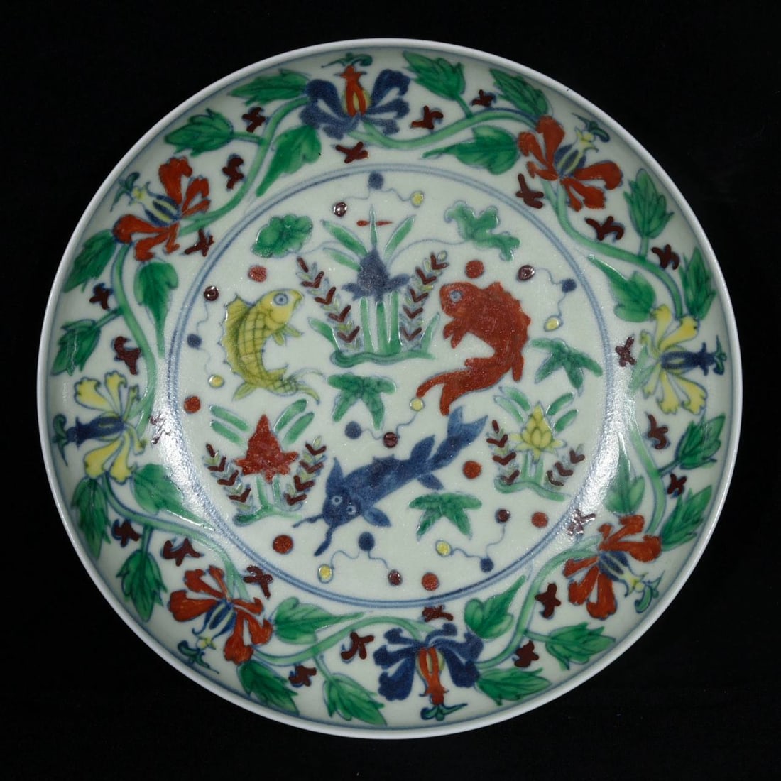 A Ming Dynasty Chenghua period doucai (enamel overglaze) dish: A Ming Dynasty Chenghua period doucai (enamel overglaze) dish with a design of intertwined flowers, fish, and algae. Height: 4.6cm; Diameter: 12.5cm