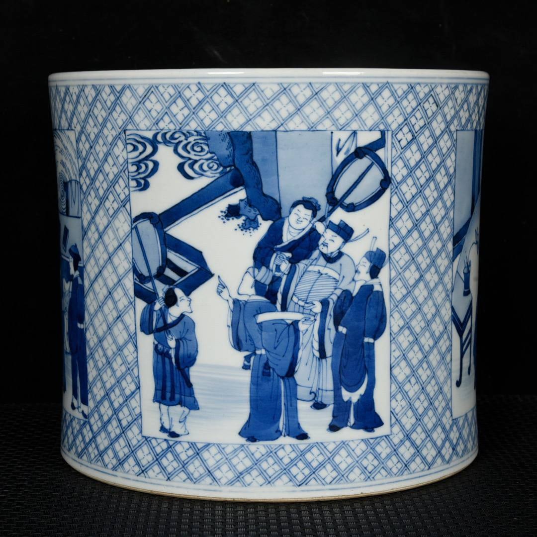 A blue and white porcelain brush pot with a scene of figures and stories depicted through openwork: A blue and white porcelain brush pot with a scene of figures and stories depicted through openwork, dating from the Kangxi period of the Qing Dynasty. Height: 17.2 cm; Diameter: 19.6 cm.