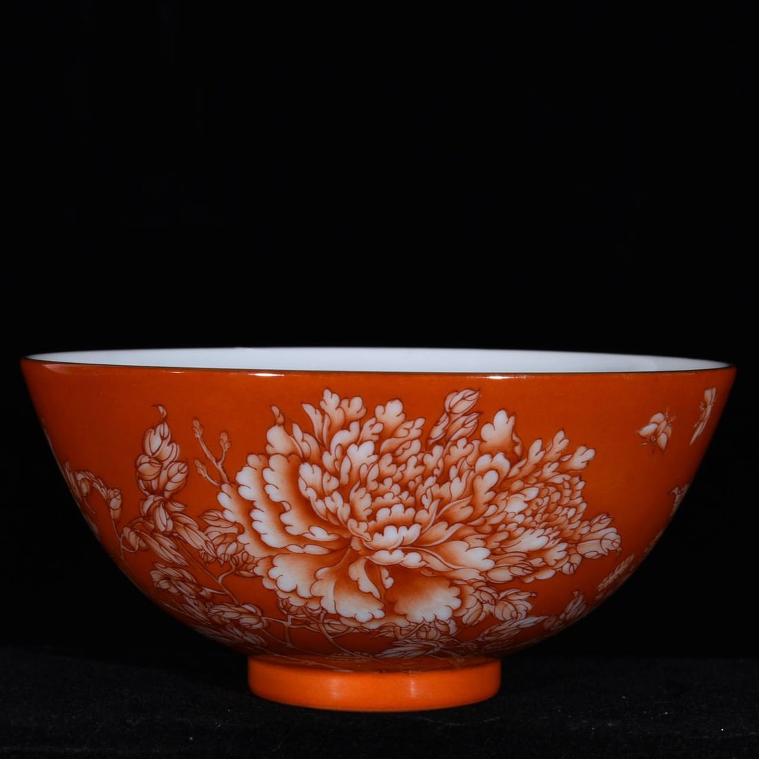 A coral-red famille rose bowl with floral and butterfly design: A coral-red famille rose bowl with floral and butterfly design, from the Yongzheng period of the Qing dynasty, 7 cm high and 14 cm in diameter.