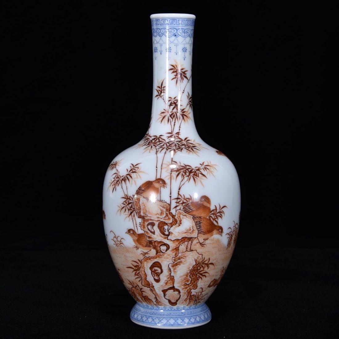 A blue-and-white porcelain vase with an overglaze red floral and bird design: A blue-and-white porcelain vase with an overglaze red floral and bird design, dating from the Yongzheng period of the Qing dynasty. Height: 19 cm. Diameter: 8 cm.