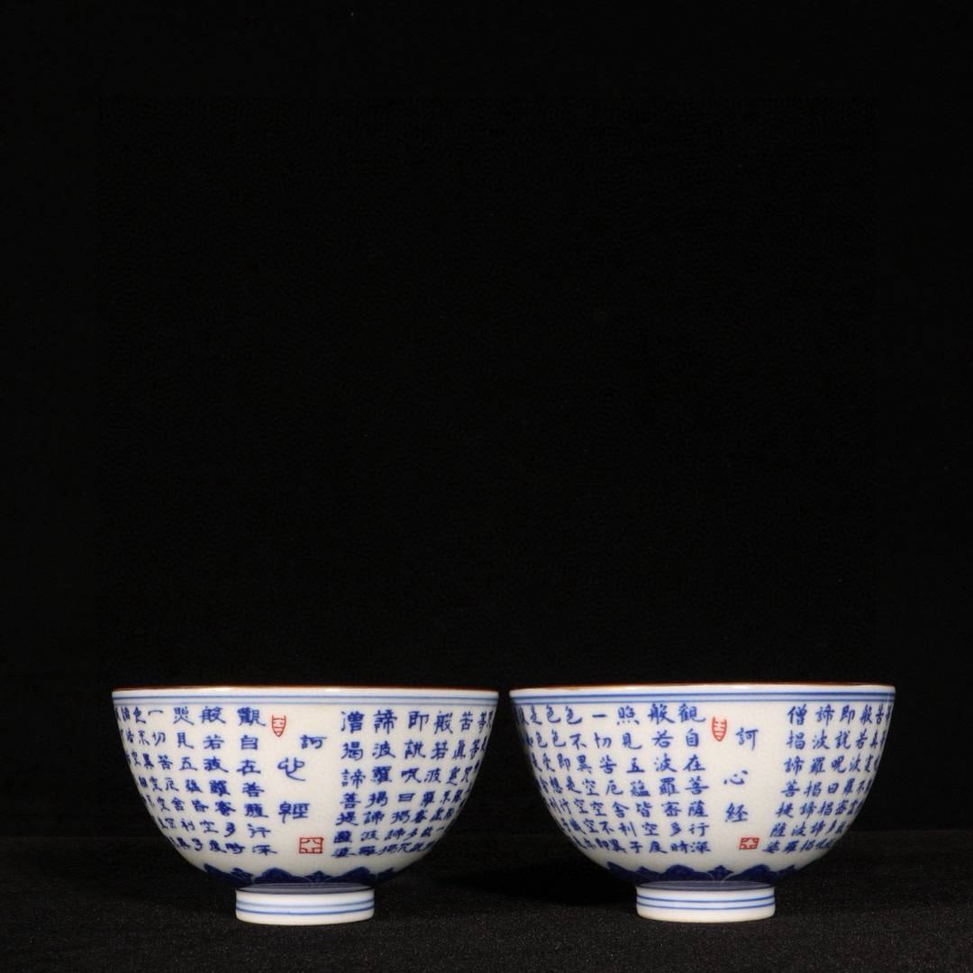 A pair of Qing Dynasty Qianlong period blue and white porcelain cups with gilt Heart Sutra design: A pair of Qing Dynasty Qianlong period blue and white porcelain cups with gilt Heart Sutra design, . Dimensions: Height 5.2 cm, Diameter 9 cm.