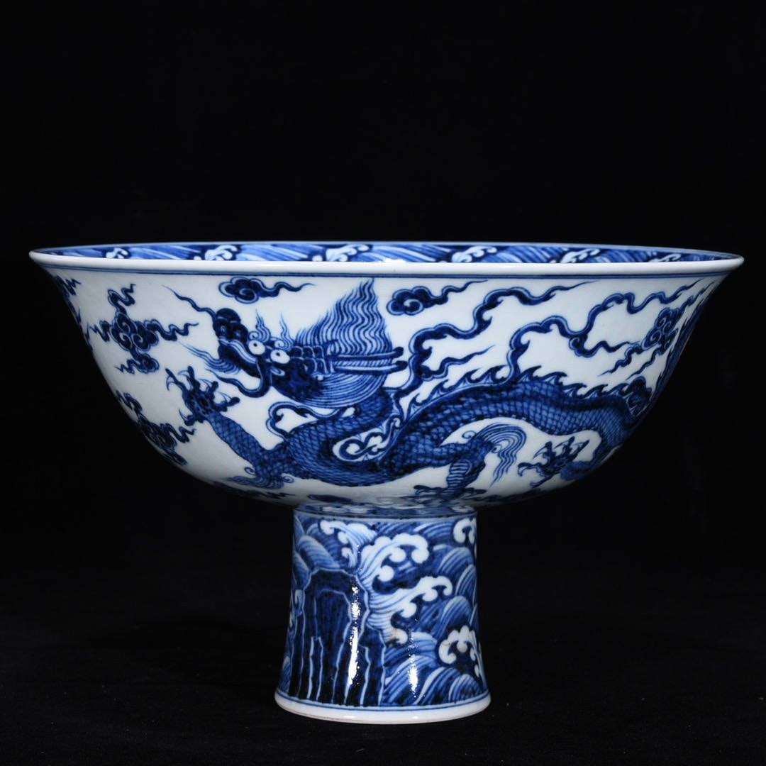 A Ming Dynasty Xuande period blue and white porcelain high-footed bowl: A Ming Dynasty Xuande period blue and white porcelain high-footed bowl with dragon and phoenix design, 16 cm high and 25 cm in diameter.