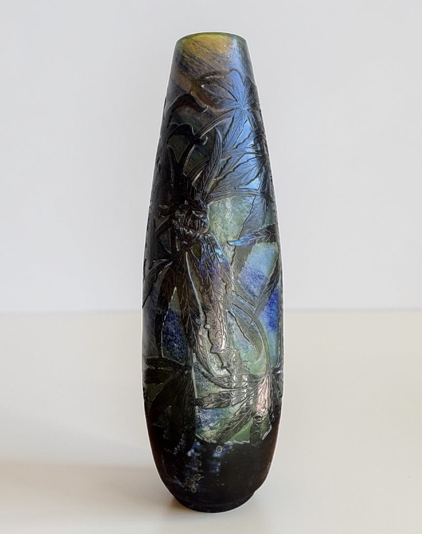 GALLÉ - INTERCALATED VASE WITH ASH DECORATION FROM BORDEAUX: A double-layered glass vase with an engraved decoration of Bordeaux ash branches. The ochre-brown leaves, embellished with iridescent blue powders partially vitrified on the surface, are deeply engrav