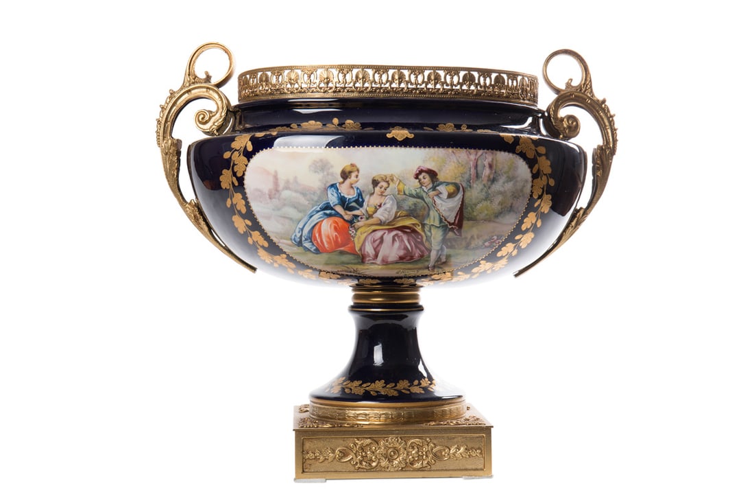 A large French porcelain bowl, de SÉVRES: A large French porcelain bowl, de SÉVRES manufactory. The cobalt blue bowl is decorated with a gallant scene framed by gilded ornamentation. It bears the signature of E. Rouly. The bowl also stands o