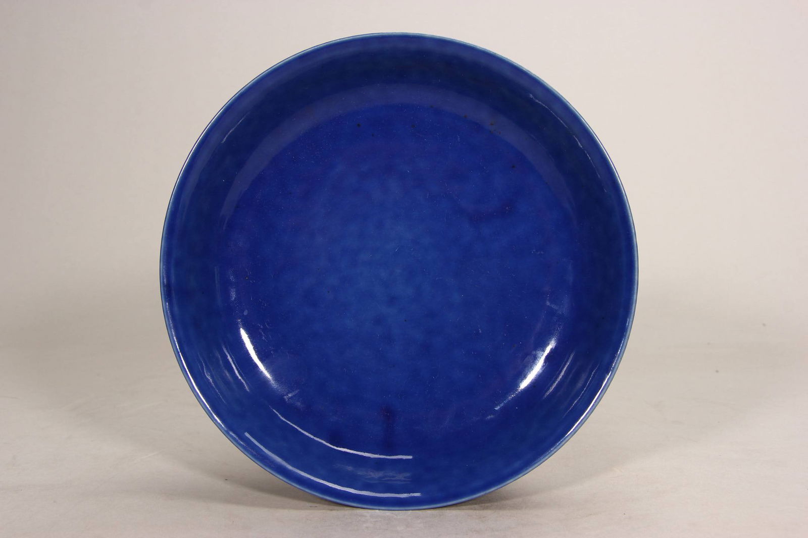 A blue-glazed dish from the Qianlong period of the Qing dynasty: A blue-glazed dish from the Qianlong period of the Qing dynasty, 18 cm in diameter.