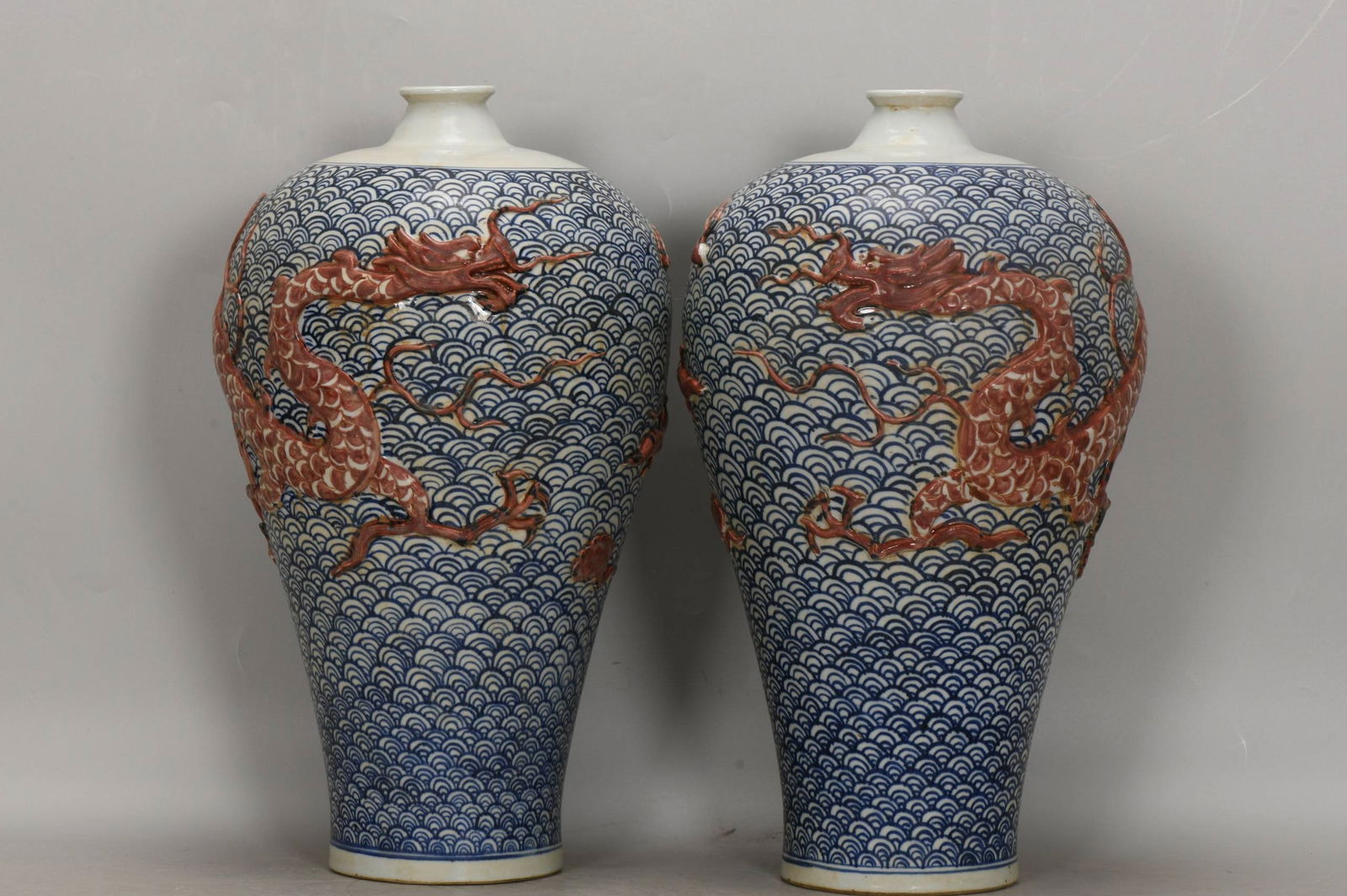 Yuan Dynasty blue and white porcelain plum vase with relief of dragon and sea wave design: Yuan Dynasty blue and white porcelain plum vase with relief of dragon and sea wave design, 43 cm high, 24 cm in belly diameter, 13 cm in base diameter.