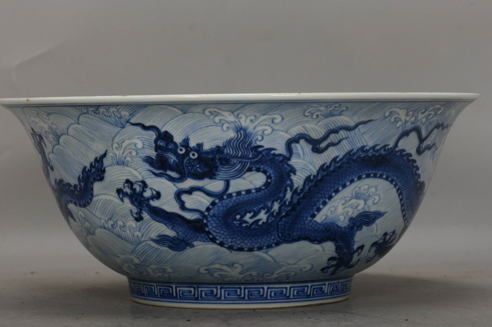 A blue and white porcelain bowl with a dragon and sea wave design from the Xuande period (1 of 7)
