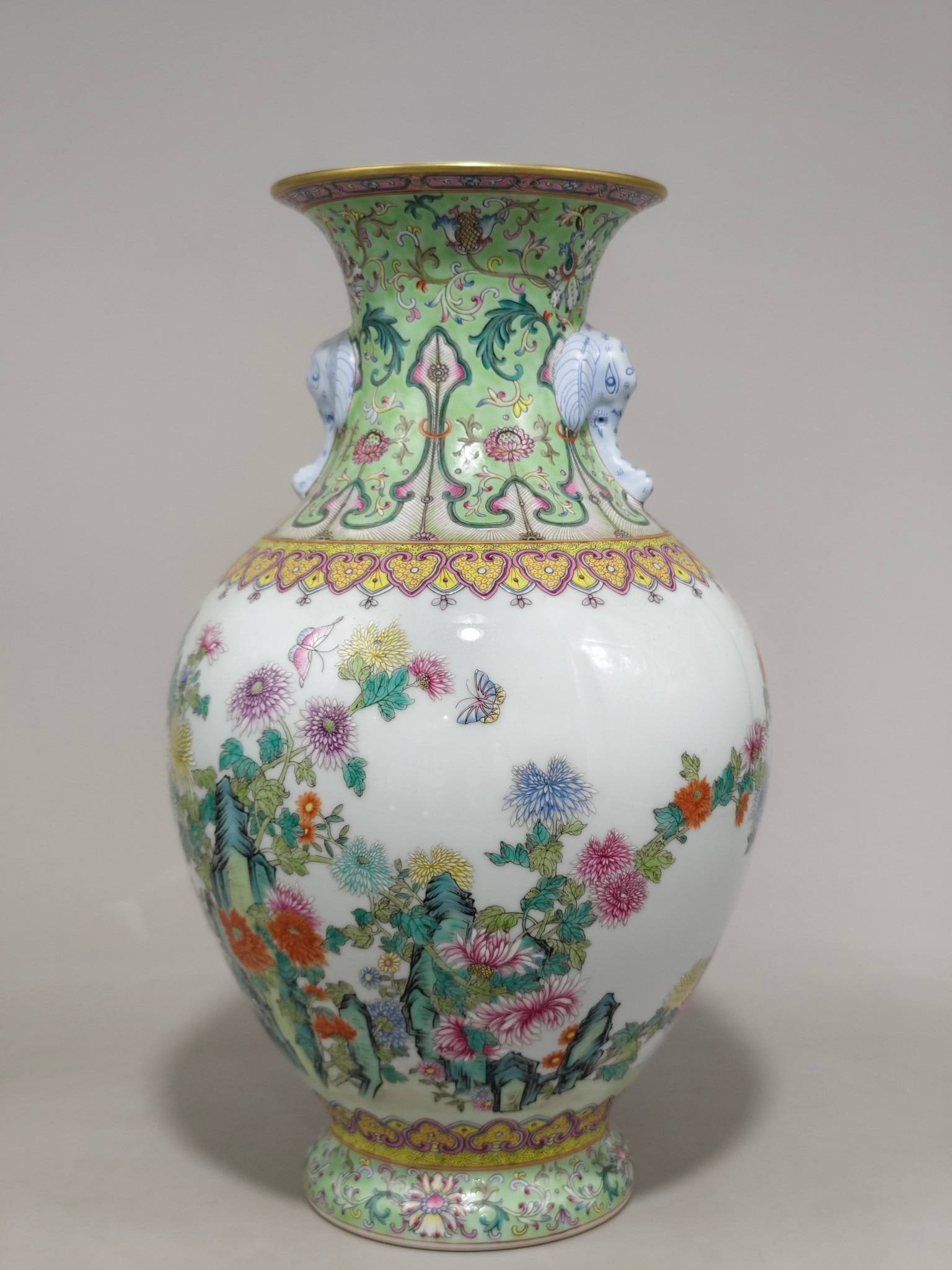 A famille rose elephant trunk vase with lotus scroll design and chrysanthemum motif: A famille rose elephant trunk vase with lotus scroll design and chrysanthemum motif in the openwork panel, bearing the mark of the Qianlong period of the Qing Dynasty. It measures 39 cm in height and