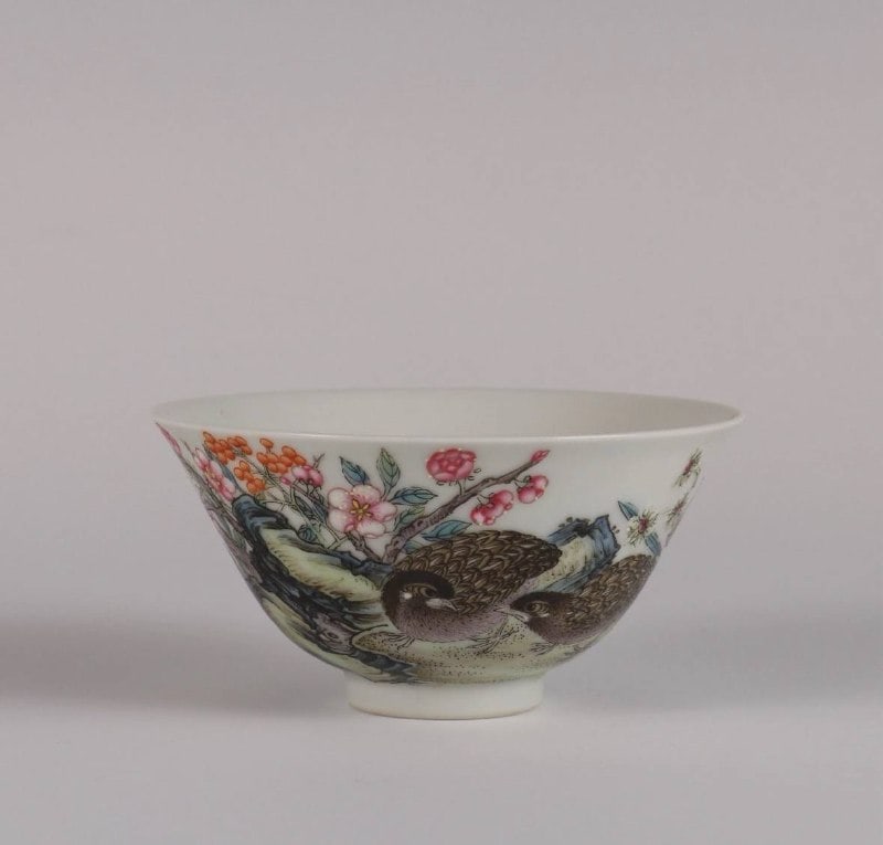 A fine Chinese famille rose bowl with floral design, Yongzheng mark: The cup is beautifully decorated in famille rose enamels, depicting a serene and prosperous scene—likely symbolic of harmony, longevity, and abundance. The soft, pastel palette and fine brushwork ar