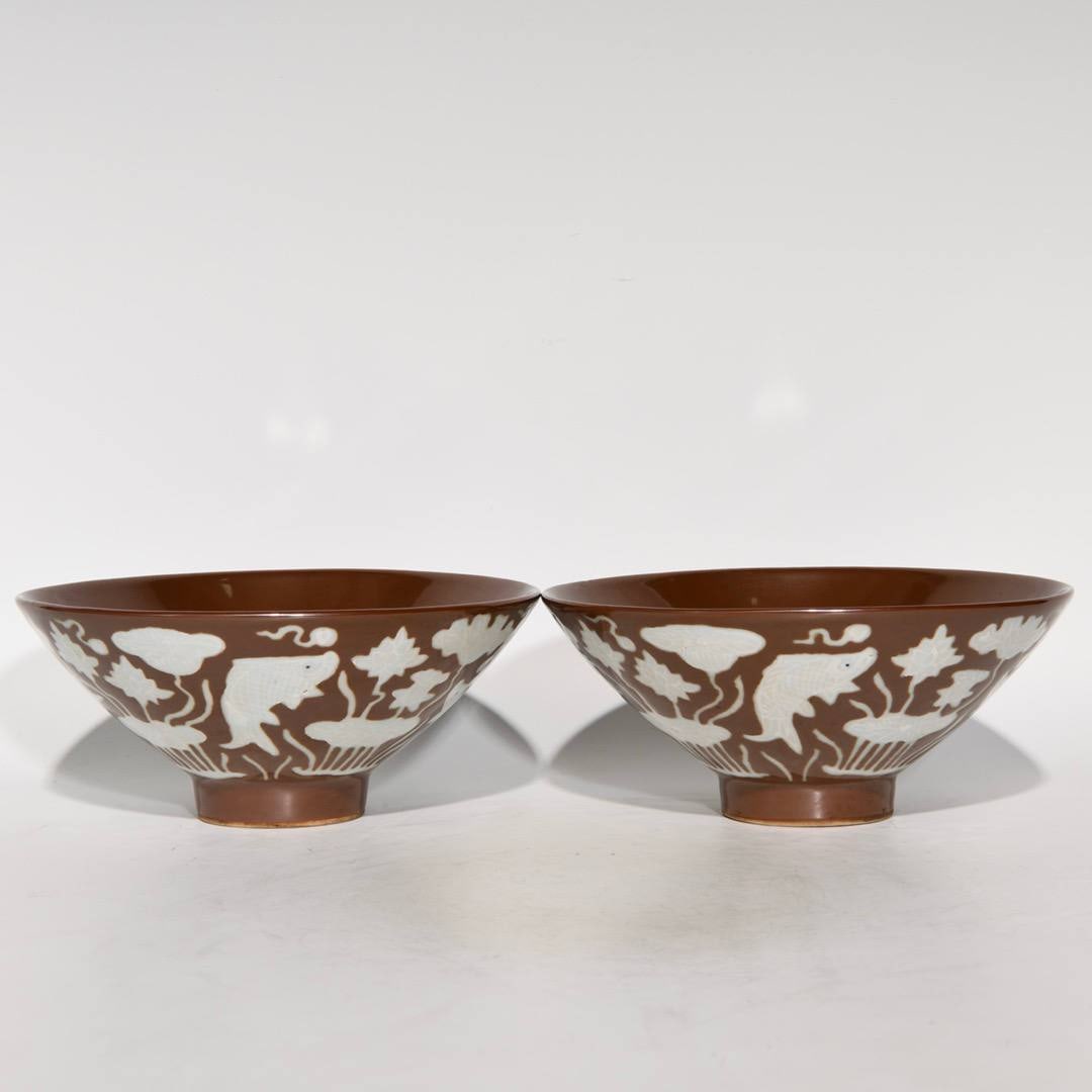 A Ming Dynasty Xuande period purple-gold glazed bowls with white fish and algae design: A Ming Dynasty Xuande period purple-gold glazed bowl with white fish and algae design, 7.2cm high and 16cm in diameter.