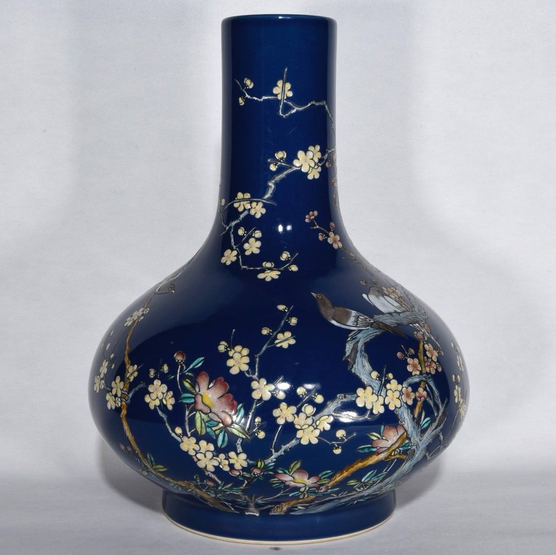 A flat-bellied vase with blue glaze and famille rose floral and bird design from the Xuantong period: A flat-bellied vase with blue glaze and famille rose floral and bird design from the Xuantong period of the Qing dynasty, measuring 32 x 24 cm.