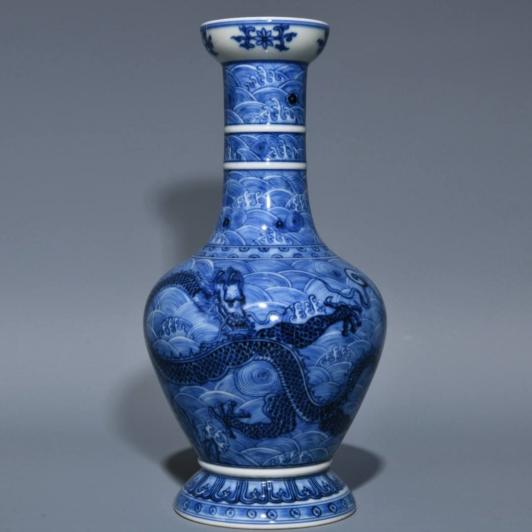 A blue and white porcelain vase with a dragon and sea wave design from the Qianlong period: A blue and white porcelain vase with a dragon and sea wave design from the Qianlong period of the Qing dynasty, 23.5 cm high and 11.5 cm in diameter.
