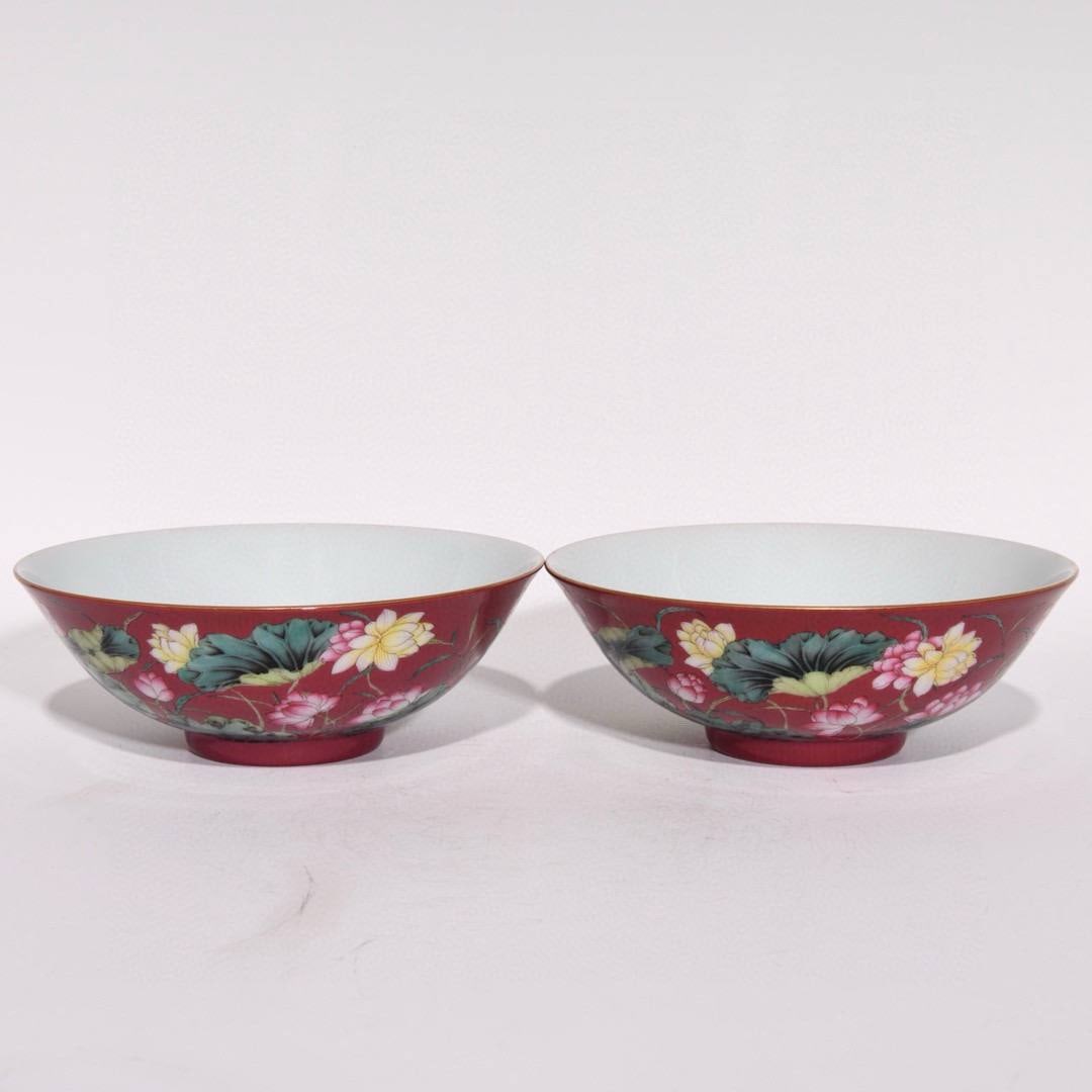 A Qing Dynasty, Yongzheng period, famille rose enamel bowls with lotus design: A Qing Dynasty, Yongzheng period, famille rose enamel bowls with lotus design on a rouge-red ground, 5.5cm high and 15.5cm in diameter.