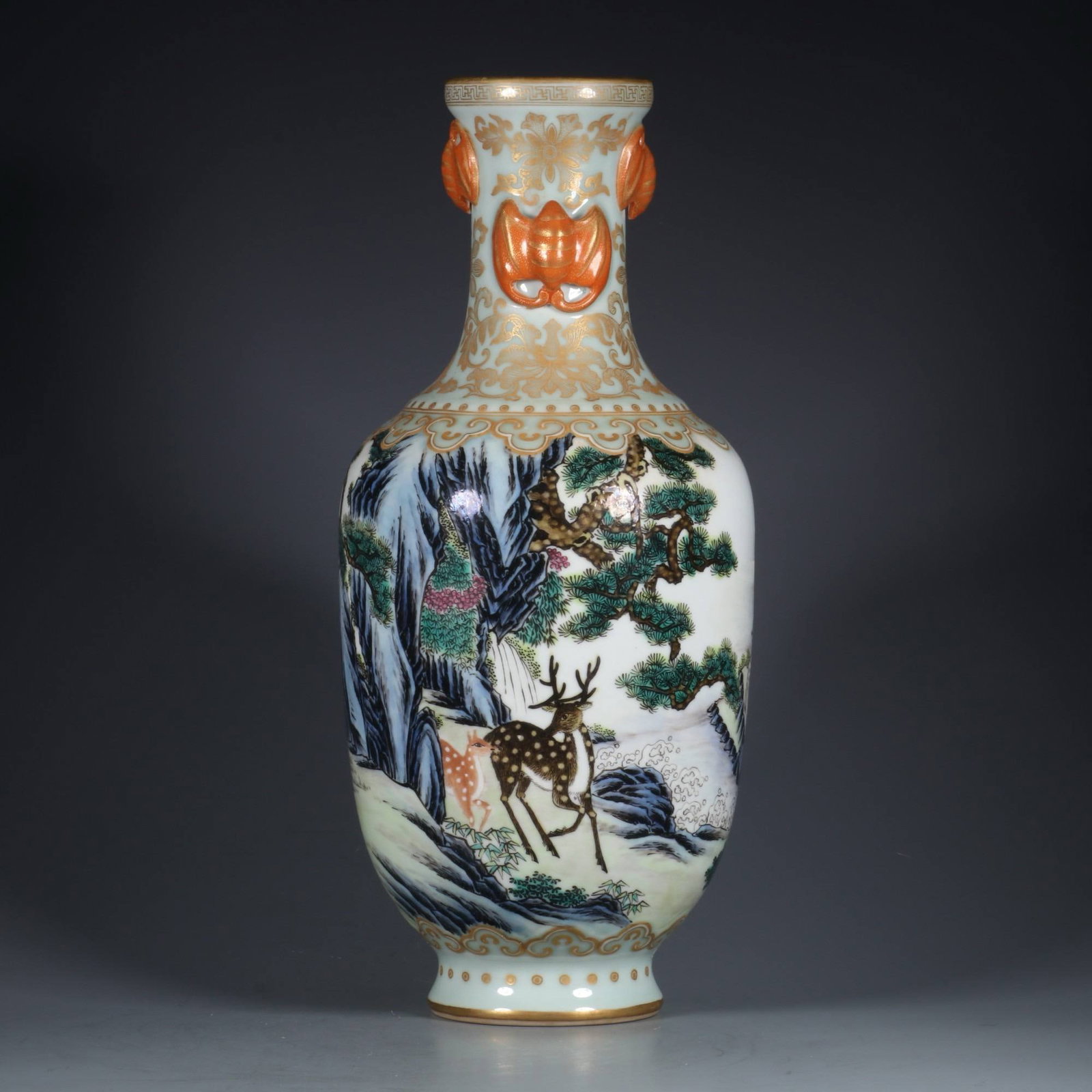 A famille rose vase with carved and gilt decoration of pine trees and deer symbolizing spring: A famille rose vase with carved and gilt decoration of pine trees and deer symbolizing spring, made during the Qianlong period of the Qing dynasty. Dimensions: Height 30.5 cm, Mouth Diameter 6.5 cm.