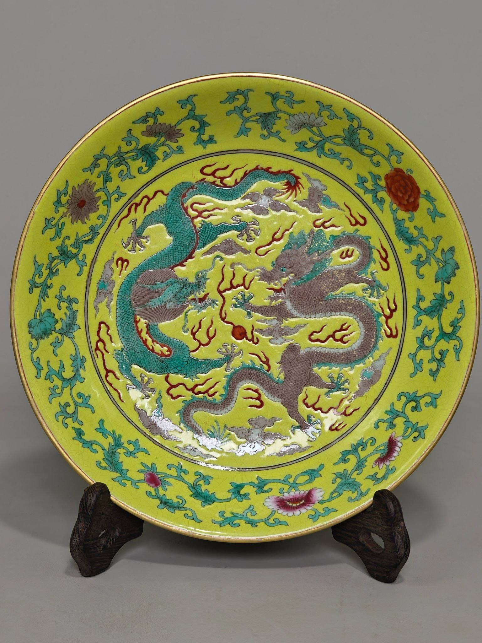 yellow plate with lotus scroll pattern and double dragons playing with a pearl design: Height 4.3 cm, diameter 20.8 cm, yellow plate with lotus scroll pattern and double dragons playing with a pearl design, marked "Made in the Tongzhi period of the Qing Dynasty".