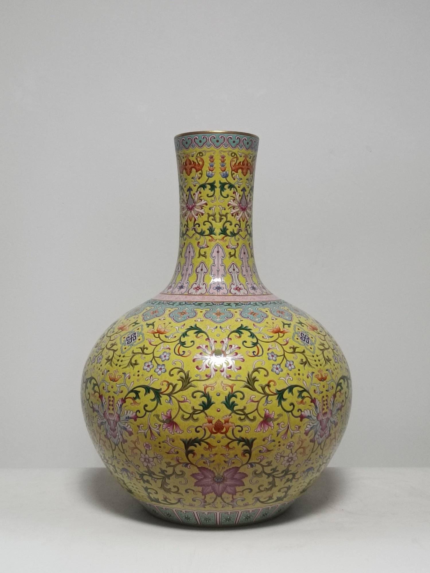 A famille rose vase with a yellow ground and the inscription "Passionflower and Longevity": A famille rose vase with a yellow ground and the inscription "Passionflower and Longevity" (symbolizing good fortune and longevity) bearing the mark of the Qianlong period of the Qing dynasty. Height: