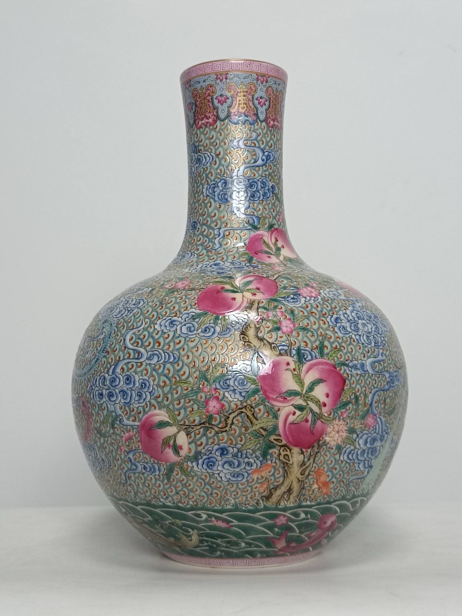 A famille rose enamel vase with dragon and phoenix motifs, fish leaping over the dragon gate: A famille rose enamel vase with dragon and phoenix motifs, fish leaping over the dragon gate, and nine peaches, bearing the mark of the Qianlong period of the Qing dynasty. Height: 40cm Width: 27cm