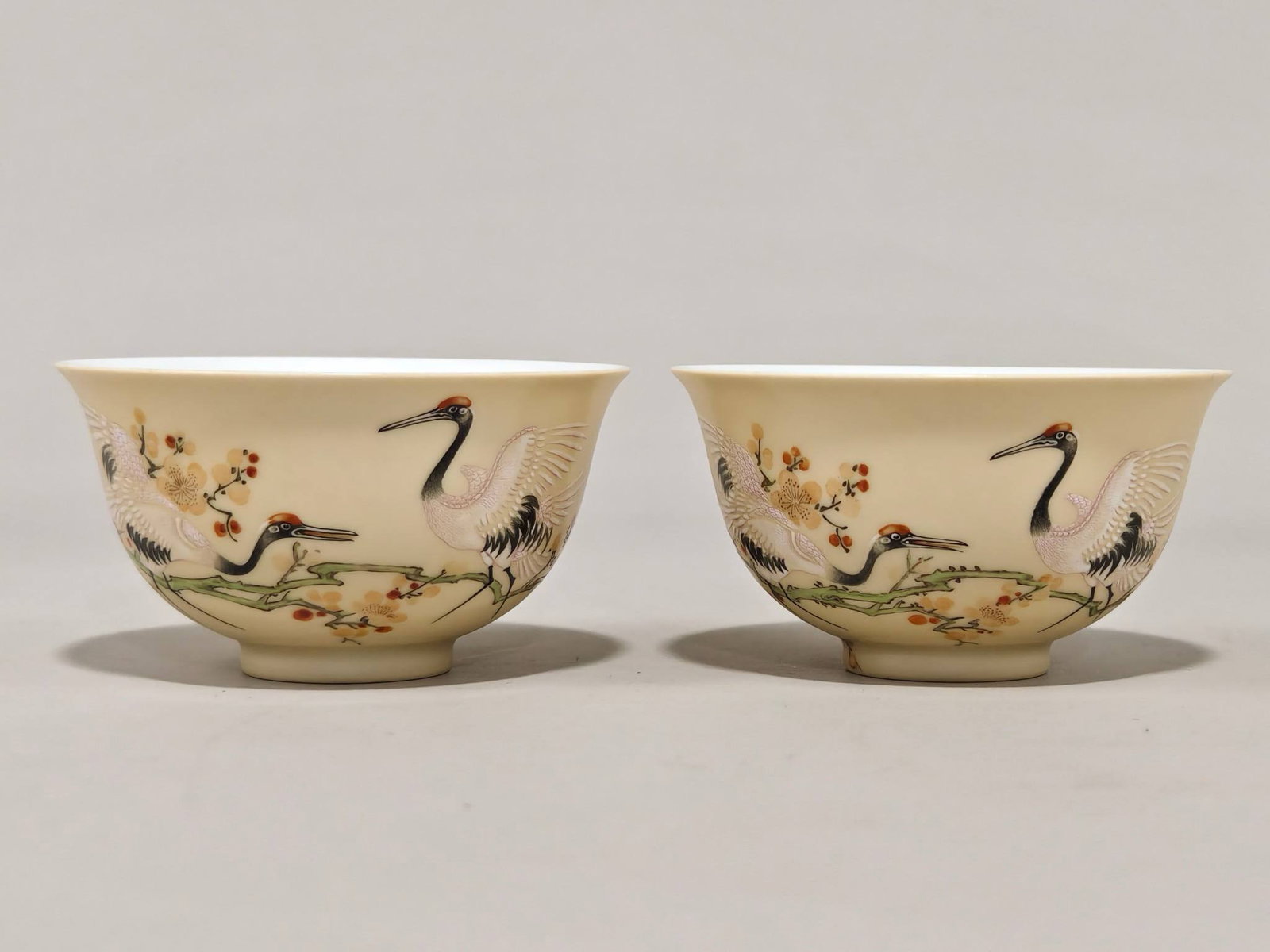 A beige-glazed plum blossom and crane cups with the mark of the Yongzheng: A beige-glazed plum blossom and crane cups with the mark of the Yongzheng period of the Qing Dynasty, measuring 4.7 cm in height and 8.8 cm in diameter.