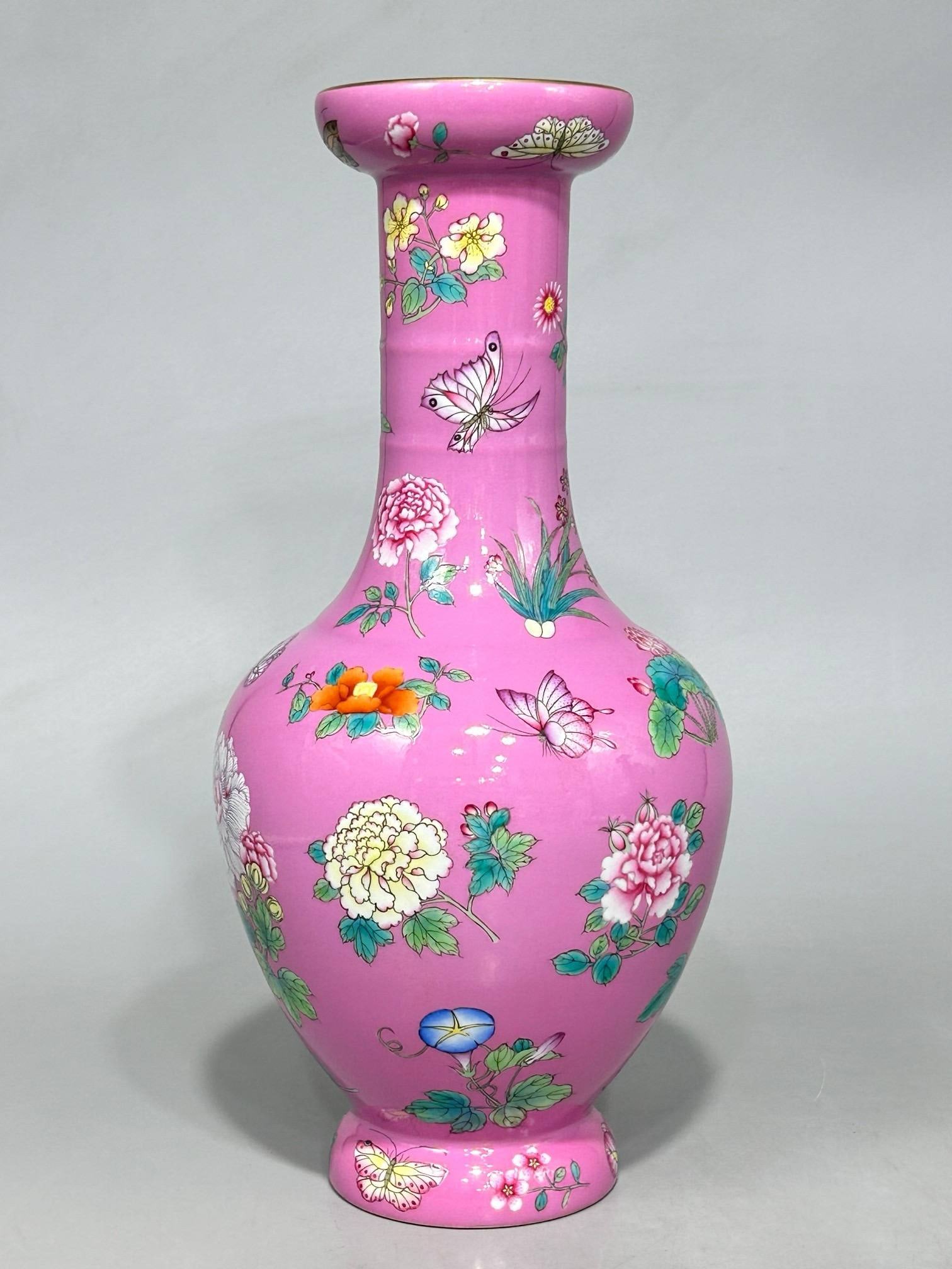 A Qing Dynasty Qianlong period famille rose vase: A Qing Dynasty Qianlong period famille rose vase with a pink base and a butterfly and flower design, measuring 33.2 cm in height and 15.5 cm in diameter.