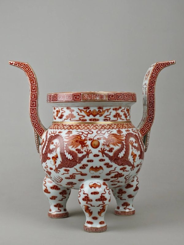A three-legged incense burner with iron-red enamel and gold decoration from the Qianlong period: A three-legged incense burner with iron-red enamel and gold decoration from the Qianlong period of the Qing Dynasty, measuring 37.8 cm in height and 38.7 cm in diameter.