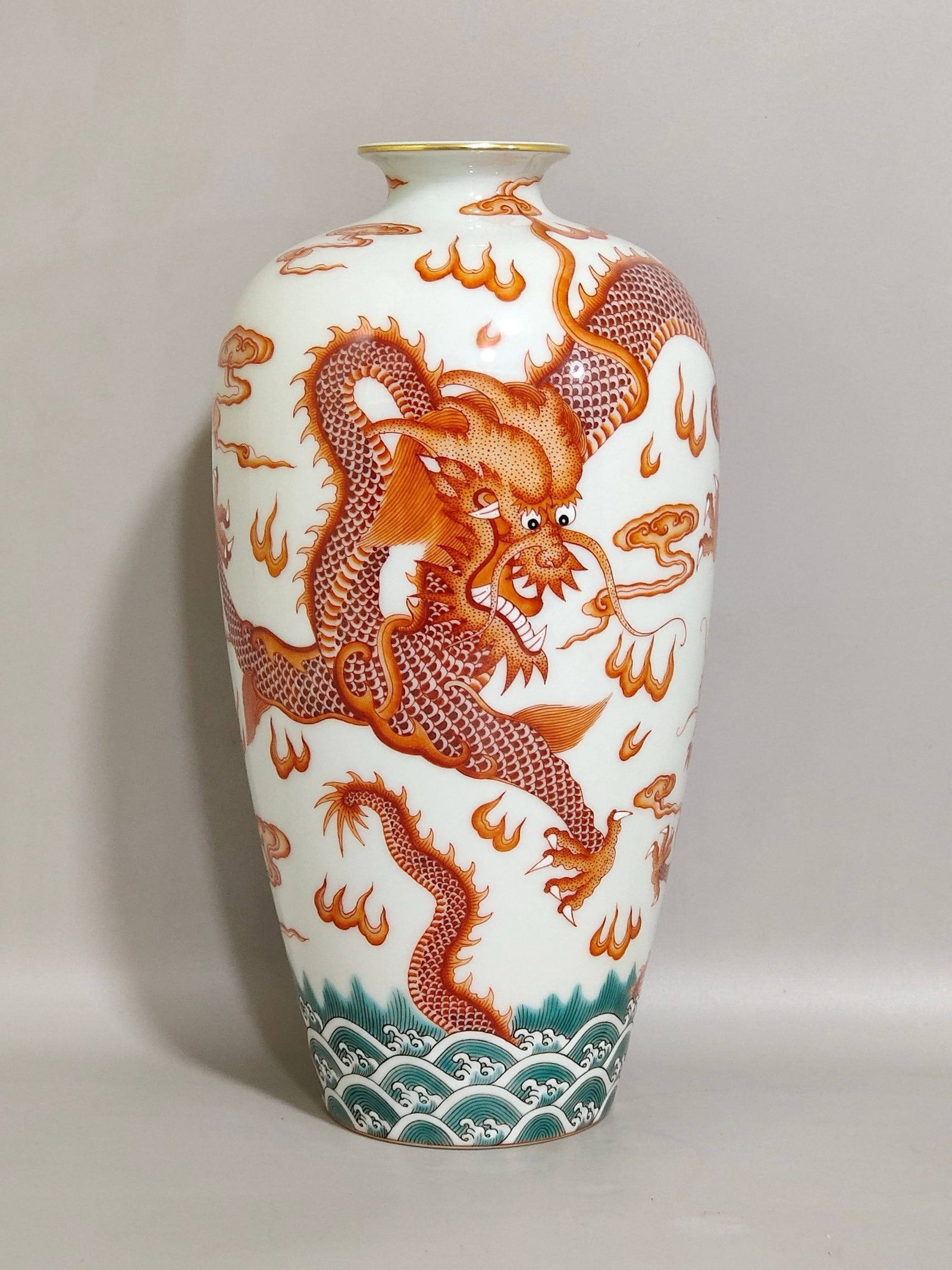 A Qing Dynasty Qianlong period iron-red plum vase with a design: A Qing Dynasty Qianlong period iron-red plum vase with a design of a dragon teaching its son, 21 cm high and 10.5 cm in diameter.