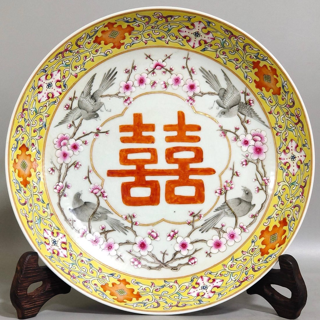 A Qing Dynasty Tongzhi period yellow-ground flower and bird plate: A Qing Dynasty Tongzhi period yellow-ground flower and bird plate, 4 cm high and 21.8 cm in diameter.